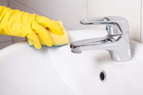 Gloved cleaner using PPE while working with cleaning supplies
